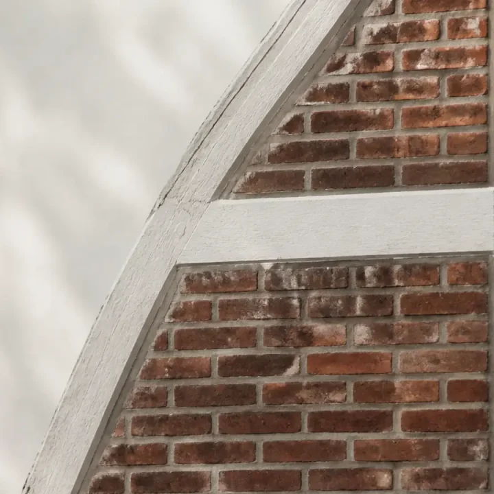Detail einer norddeutschen Backsteinfassade mit weiß gefasstem Fachwerk im diffusen Tageslicht